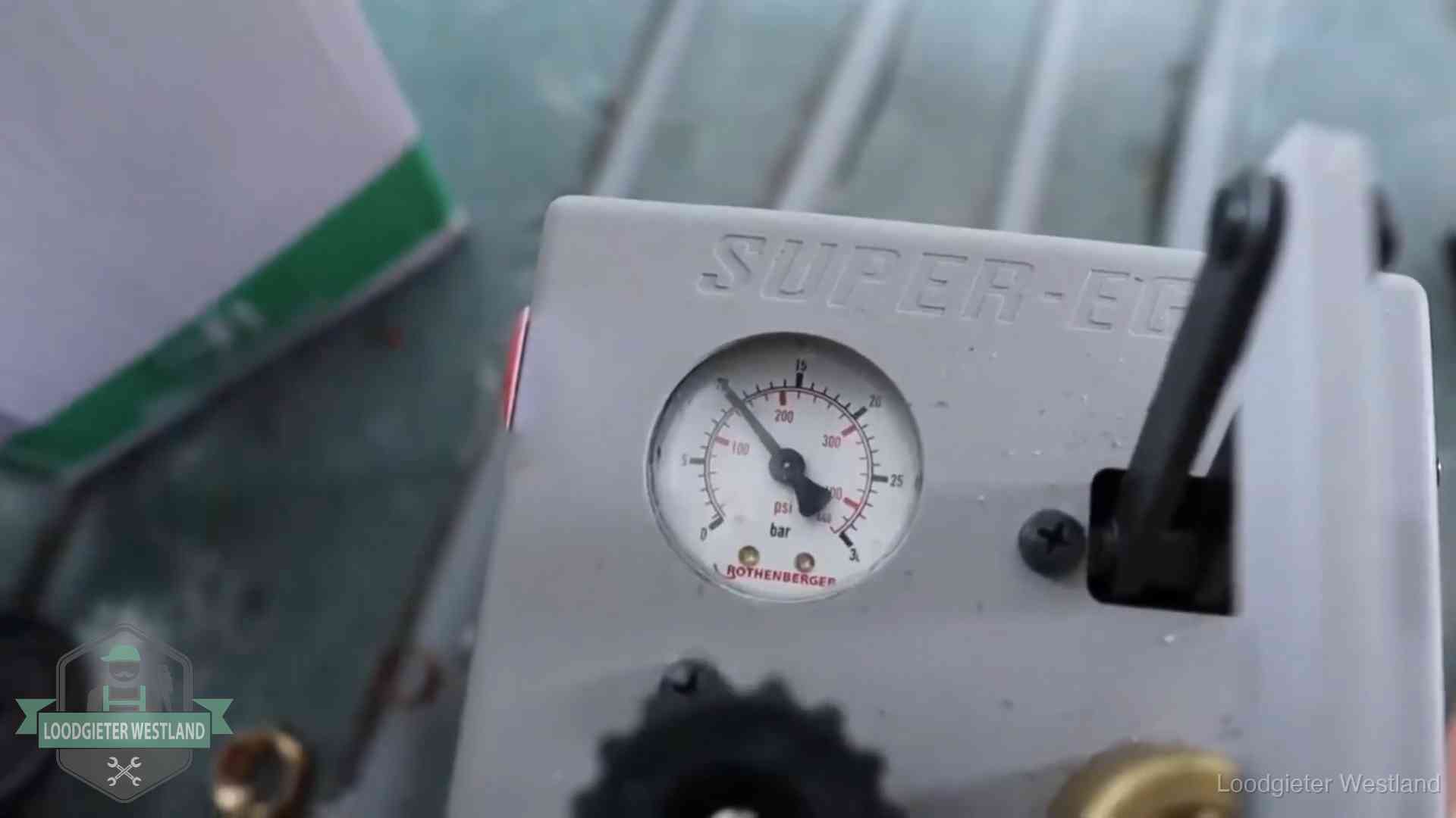 Manometer van een afperspomp bij controle van nieuw leidingwerk in Westland