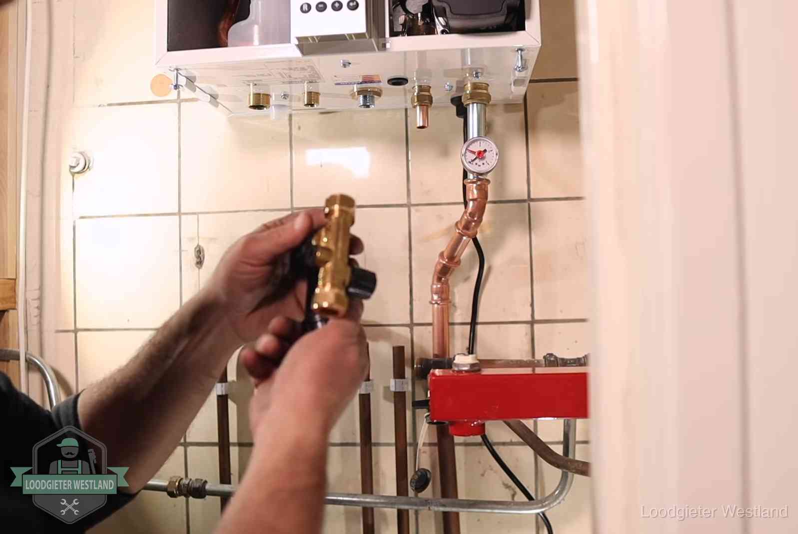 Vulkraan en manometer onder een cv-ketel voor het bijvullen van de waterdruk in Westland