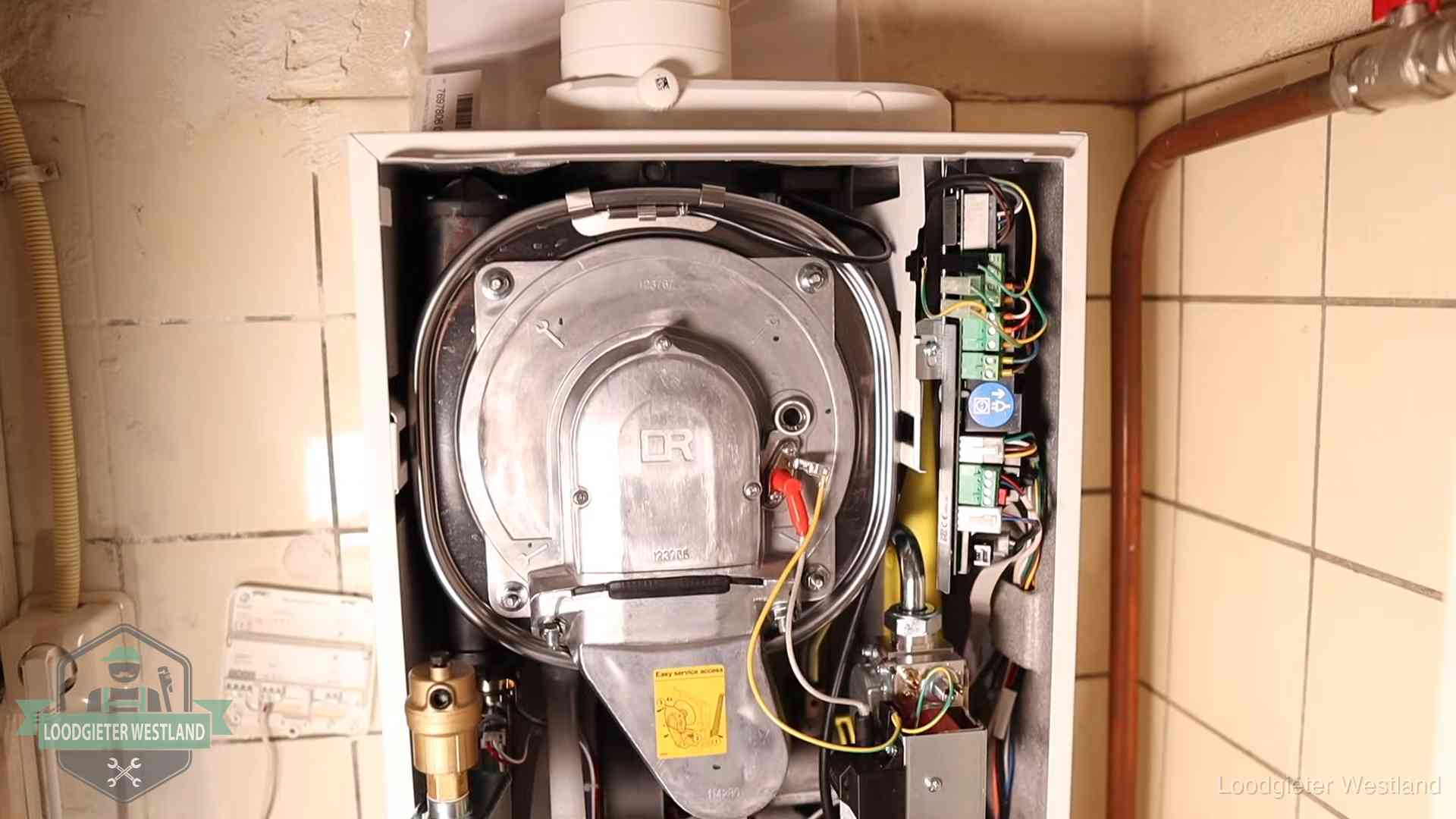 Geopende cv-ketel met warmtewisselaar tijdens periodiek onderhoud in Westland