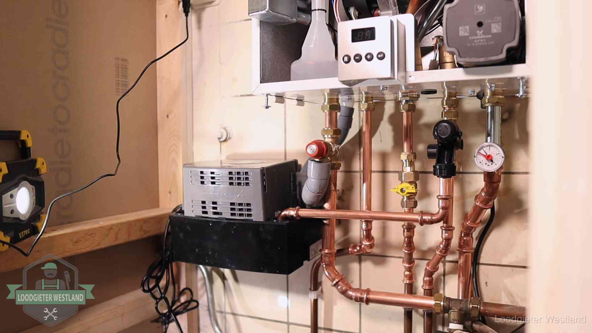 Nieuw koperen leidingwerk met pomp en manometer onder een vervangen cv-opstelling in Westland