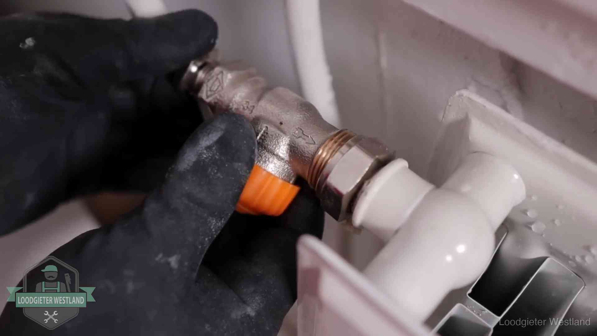 Thermostaatkraan wordt gemonteerd op een radiator in Westland voor het stookseizoen