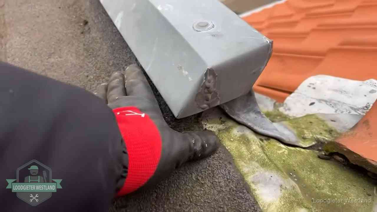 Hemelwaterafvoer en dakgoot controleren in Westland Controle van een zinken hemelwaterafvoer met loodslab bij dakpannen in Westland