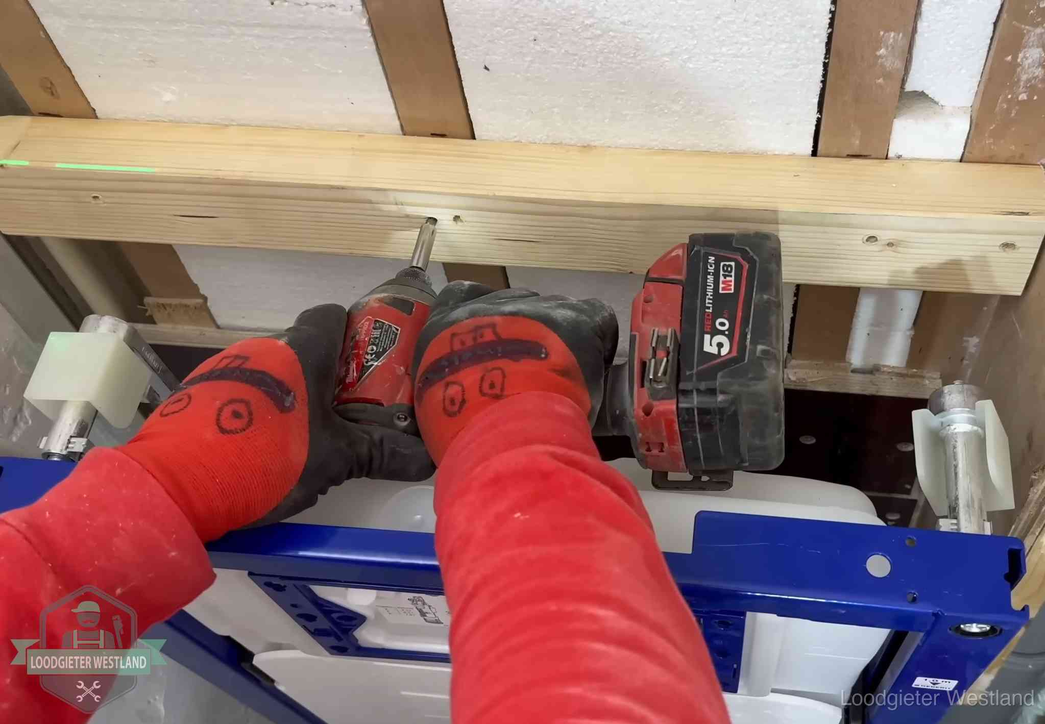 Fout in de wc-installatie opsporen in Westland Monteur bevestigt een inbouwreservoir voor een hangend toilet in Westland