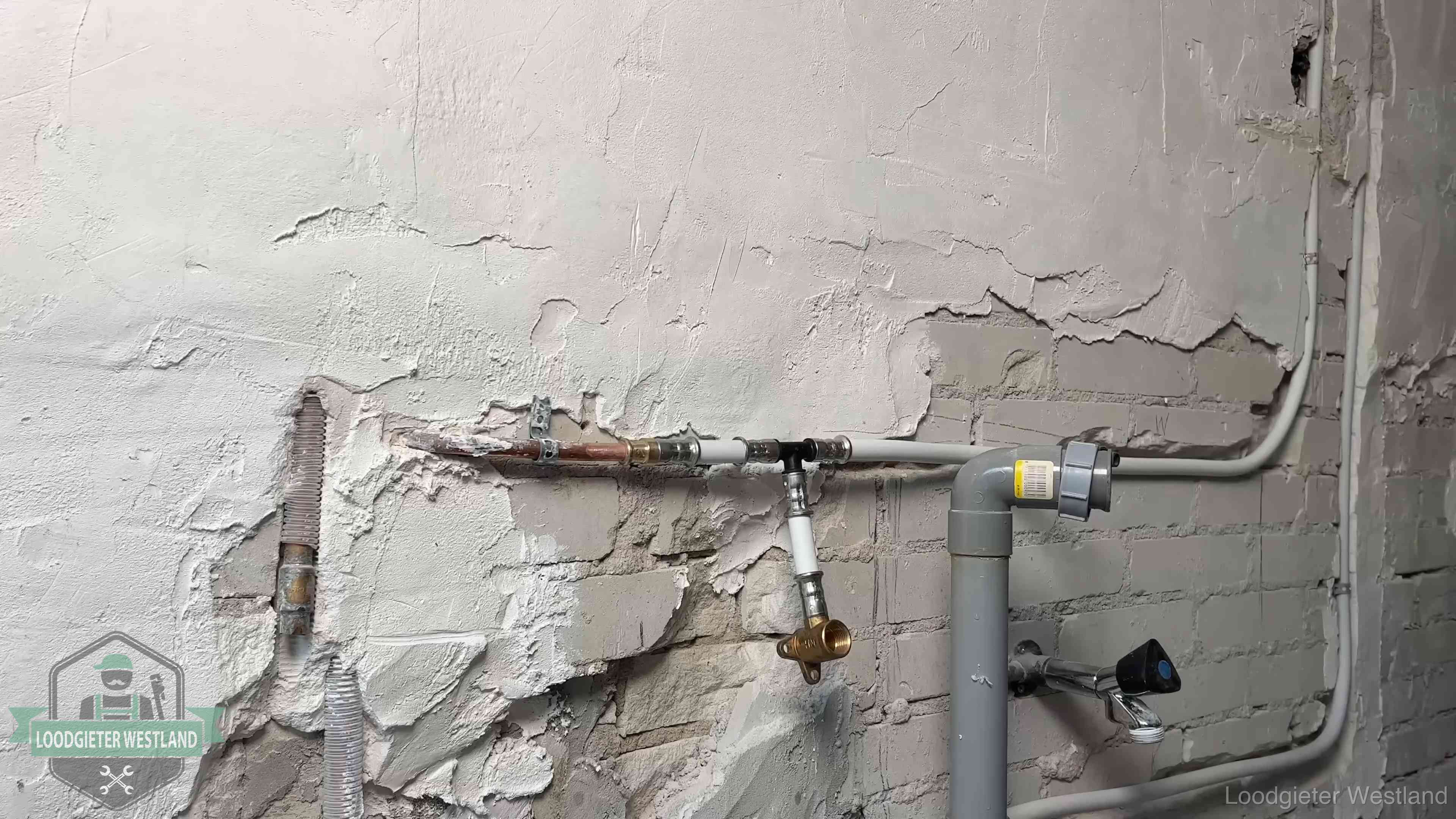 Nieuw leidingwerk naast een oud verroest leidingrestant in een woning in Westland