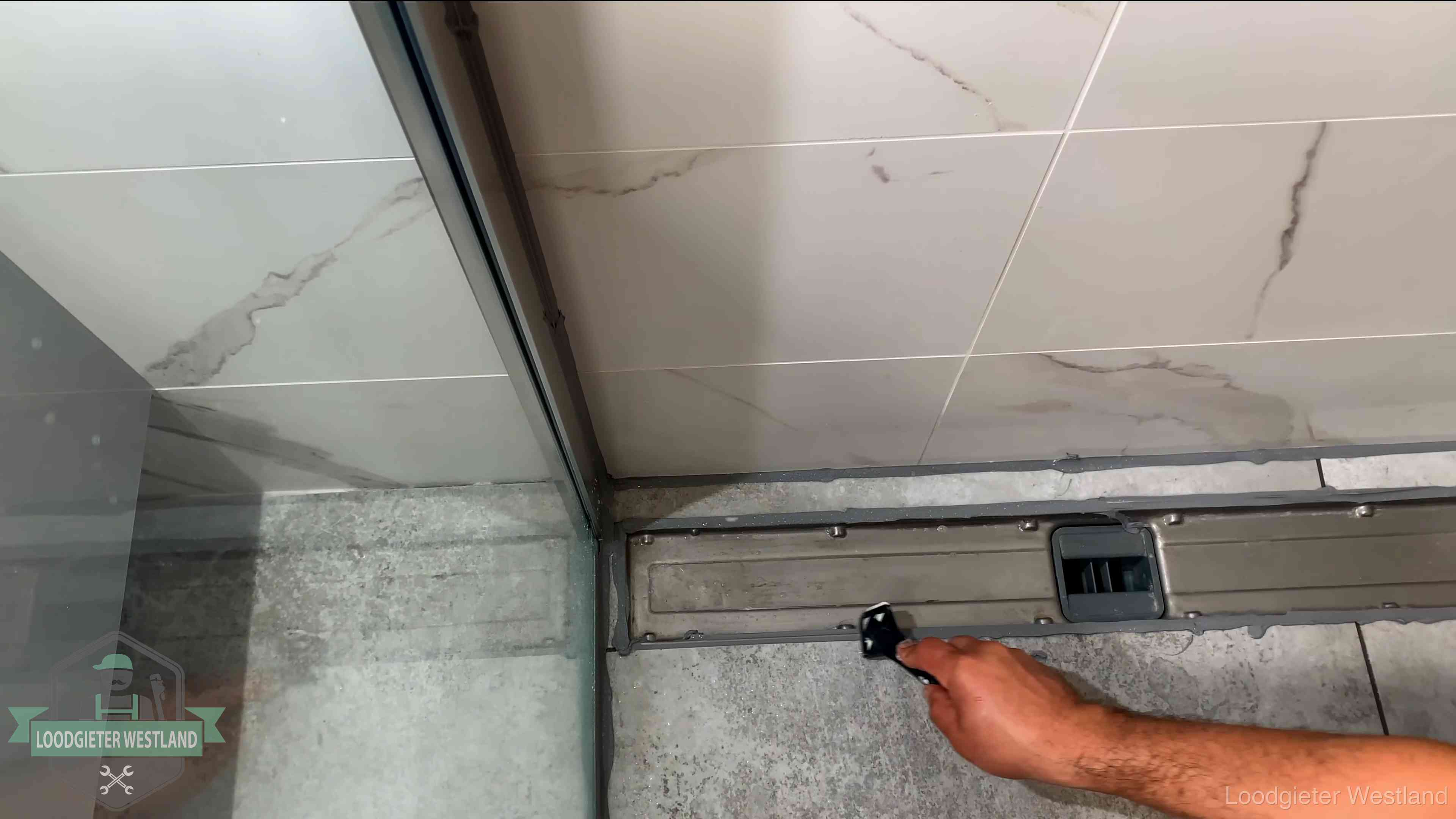 Verse kitrand langs de douchegoot in een betegelde badkamer in Westland