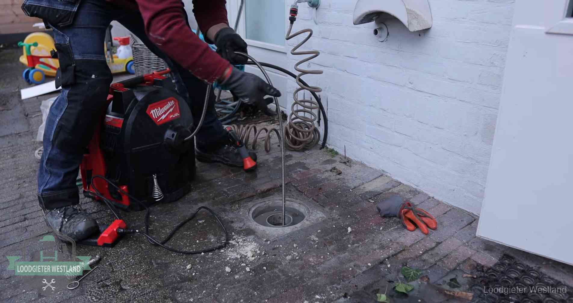 Erfgrens en gemeenteriool in Westland Ontstoppingsputje in de bestrating naast de gevel van een woning in Westland