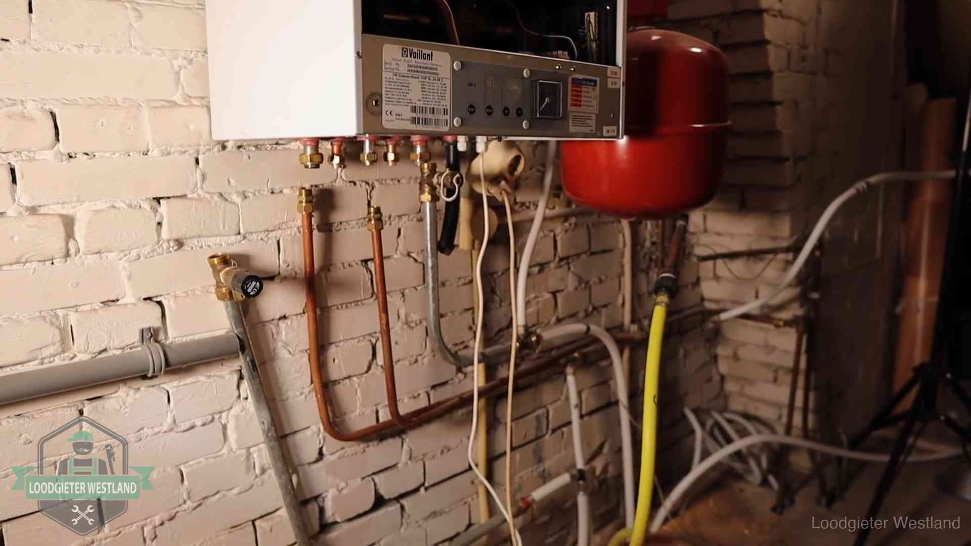 Verouderde cv-ketel met een wirwar van oude leidingen in een woning in Westland