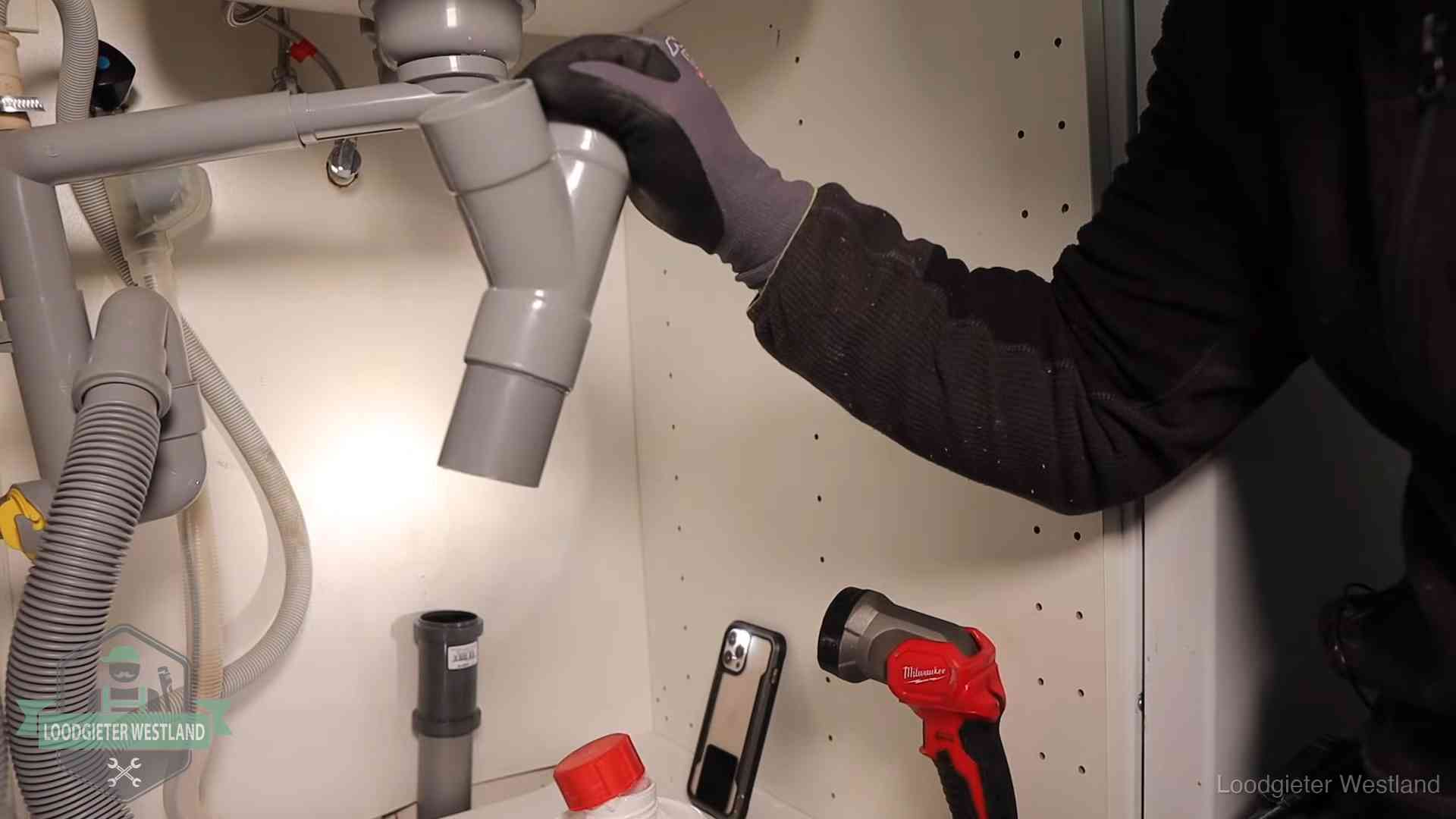 Rioollucht in huis verhelpen in Westland Loodgieter demonteert het sifon- en afvoerwerk onder een gootsteen in Westland bij stankklachten