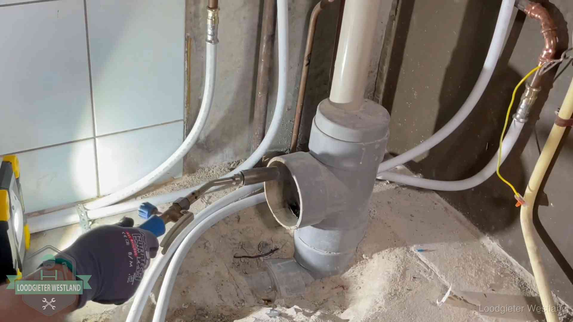 Verstopping in een huurwoning in Westland Loodgieter werkt aan leidingen bij de pvc-standleiding van een huurwoning in Westland
