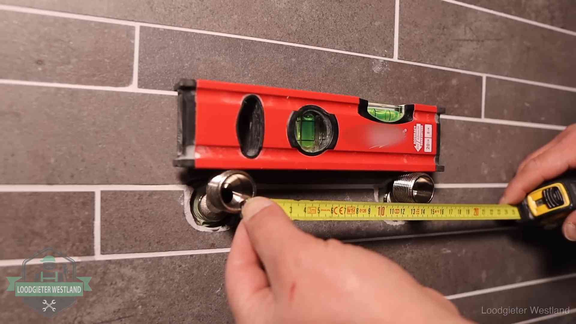 Waterpas en duimstok bij kraan-aansluitpunten in een badkamer in Westland