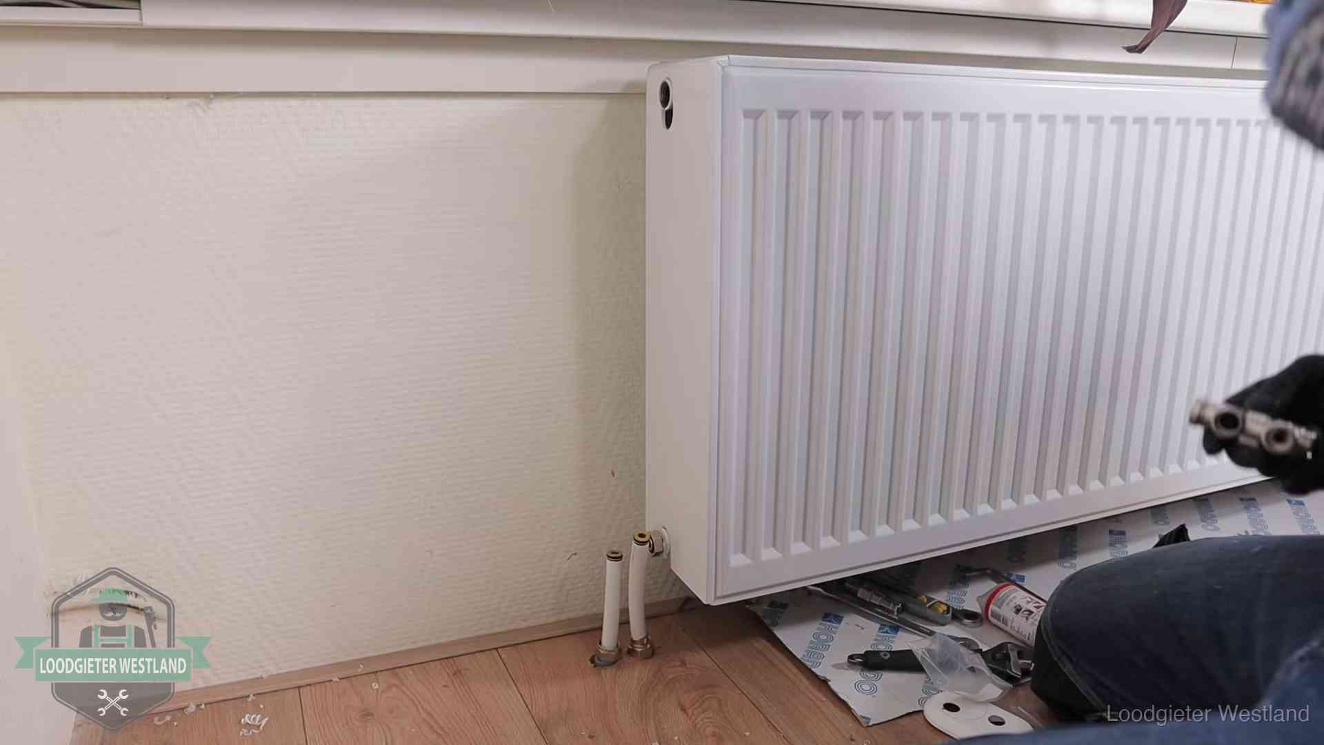Nieuw gemonteerde radiator in een woonkamer in Westland