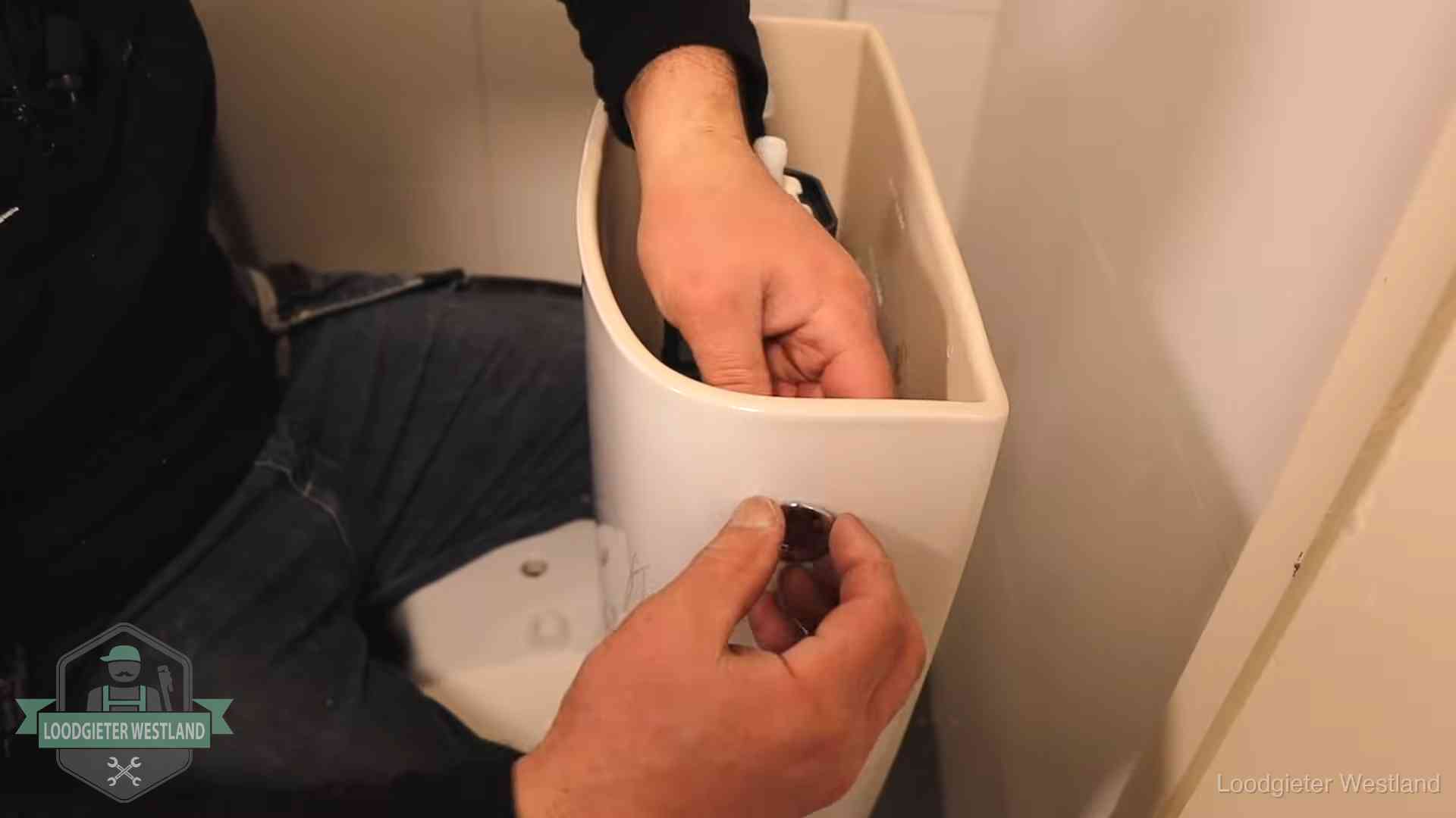Je wc verstoppingsvrij houden in Westland Drukknop van een duoblok-stortbak wordt gemonteerd bij een toilet in Westland