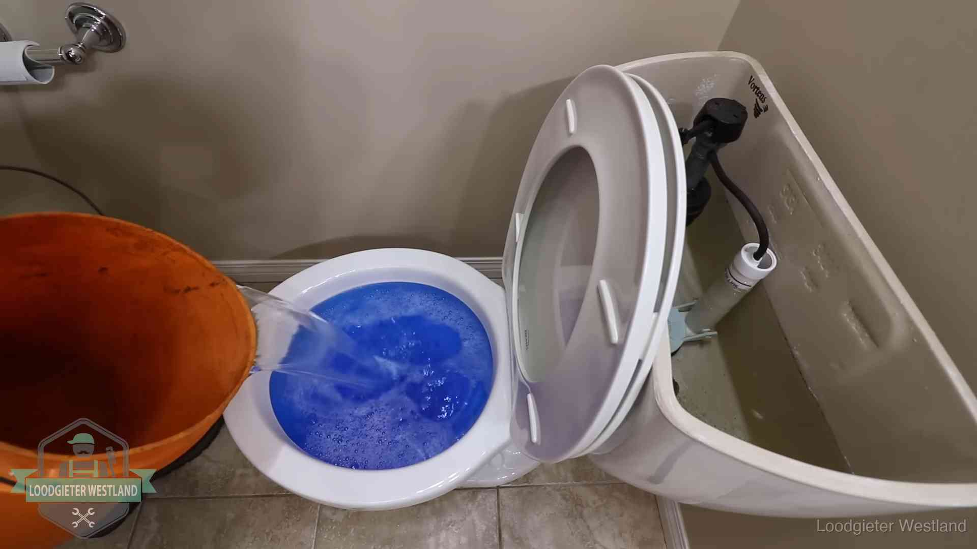 Water komt omhoog in de wc in Westland Water bij de wc-pot wordt met een emmer weggewerkt om schade te beperken in Westland